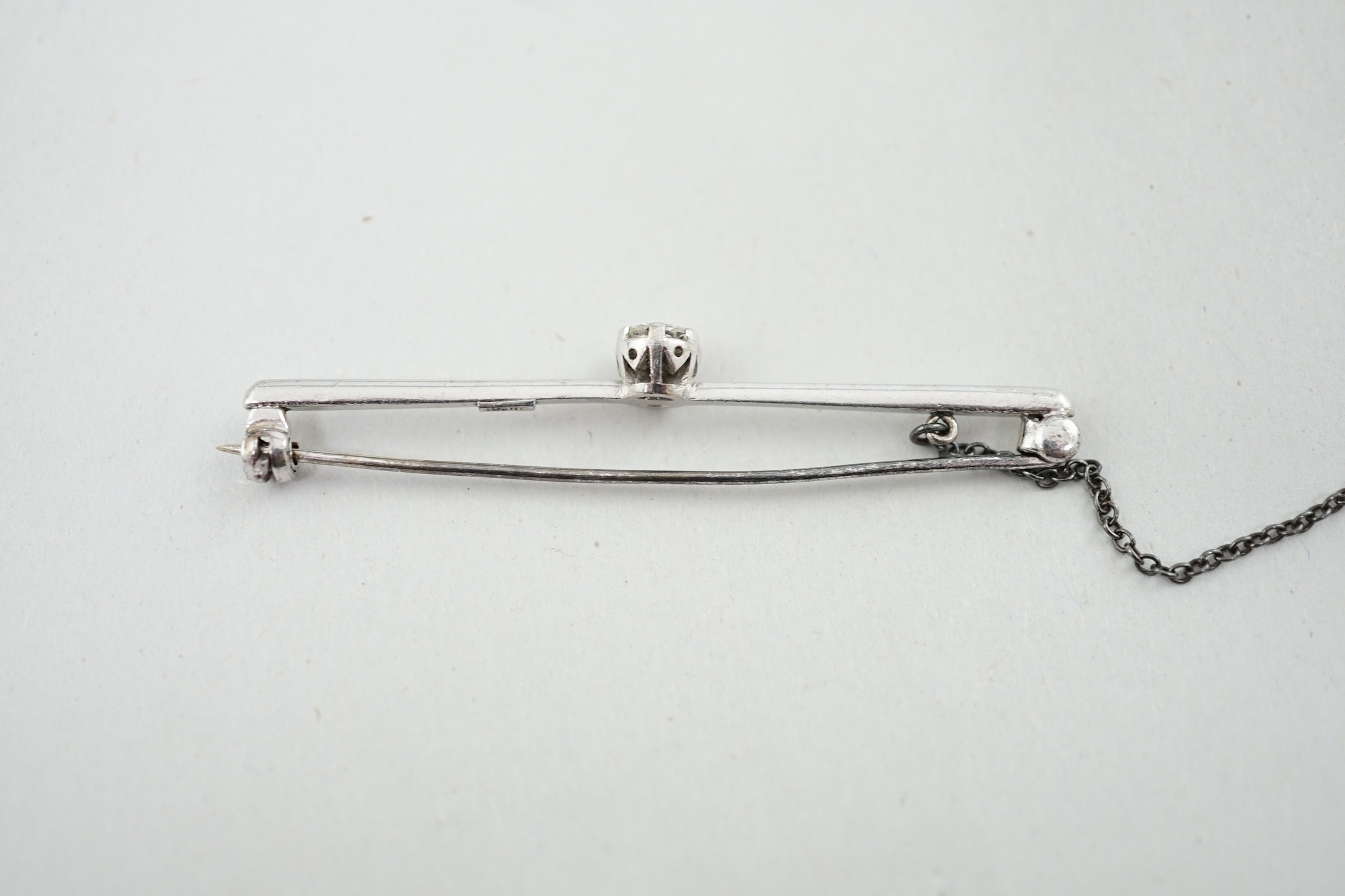 An 18ct white gold and illusion set solitaire diamond set bar brooch